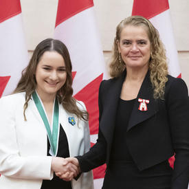 Alana Robert is posing for a picture with the Governor General. 