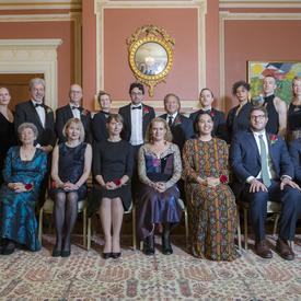 Photo de groupe des seize lauréates et lauréats des Prix littéraires du Gouverneur général de 2018 avec la Gouverneure générale Julie Payette et Simon Brault.  La rangée avant est assise, la rangée arrière est debout.