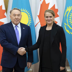 La gouverneure générale serre la main de Nursultan Nazarbayev, président du Kazakhstan.  Ils sourient pour la caméra.  Derrière eux se trouvent les drapeaux canadiens et kazakhs.