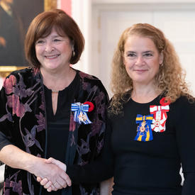 La gouverneure générale se tient à côté du récipiendaire Rachel Corneille Gravel, qui porte de la Médaille du service méritoire (division civile) qu'elle vient de recevoir.