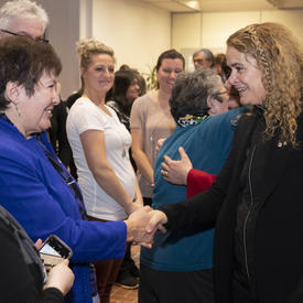 La gouverneure générale, Julie Payette, rencontre des gens dans une foule.  Elle est photographiée en train de serrer la main d'une femme.