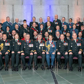 Une photo de groupe des 69 membres nouvellement investis de l'Ordre du mérite militaire. Le Vice-chef d'état-major   de la Défense, le Lieutenant-général Paul Wynnyk, et Son Excellence la très honorable Julie Payette sont assis au   centre du premier rang