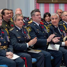 Recipients of the Order of Merit of the Police Forces sit together during an investiture ceremony. 
