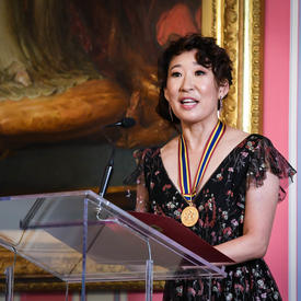 Sandra Oh prononce une allocution à partir du podium.  