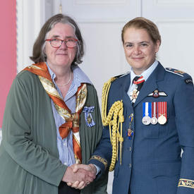 Sally Goddard accepte sa médaille et serre la main de la gouverneure générale.