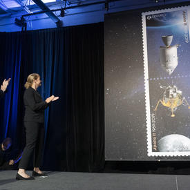 La gouverneure générale applaudit sur scène alors que les timbres Apollo 11 sont dévoilés.