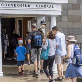Les visiteurs entrent dans la résidence du gouverneur général. 