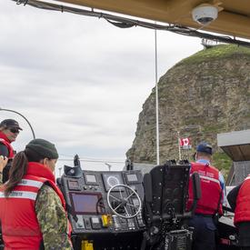A photo of the CCGS Baie de Plaisance and crew at sea performing a search and rescue demonstration.