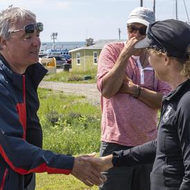 La gouverneure générale rencontre et serre la main d'un résident de l'Île d'Entrée.