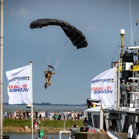 Un parachutiste se prépare à atterrir pendant la cérémonie commémorative à Terneuzen.