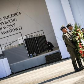 Une photo de deux soldats polonais tenant une couronne lors de la cérémonie commémorative.