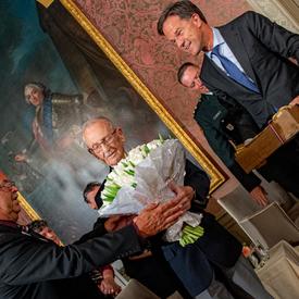Le premier ministre des Pays-Bas remet des tulipes et une boîte de bulbes à l'ancien combattant canadien Don White.