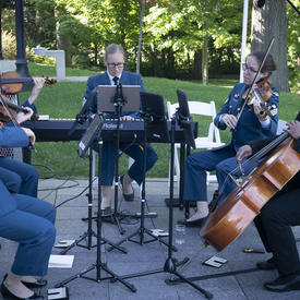 Une photo de musiciens des Forces armées canadiennes jouant lors d'une cérémonie mixte à l'extérieur de Rideau Hall.