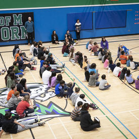  The Governor General speaking to students in a gymnasium. 