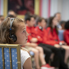 Une jeune élève écoute attentivement pendant la période de questions et réponses avec la gouverneure générale.