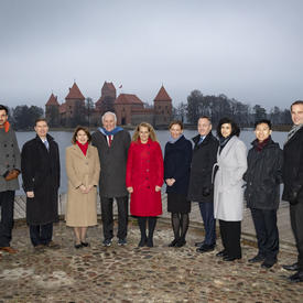 The Governor General and the Canadian delegation is posing for a photo in front of Trakai Castle. 