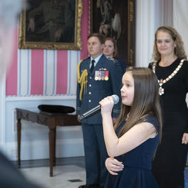 L'hymne national est chanté par une jeune femme lors de la cérémonie de l'Ordre du Canada.