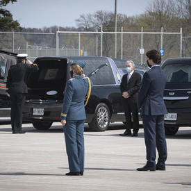  La gouverneure générale salue un cercueil placé dans un corbillard. Le premier ministre se tient derrière elle. 