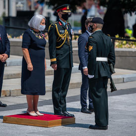 La gouverneure générale Mary May Simon se tient sur une petite plateforme rouge devant le Monument commémoratif de guerre du Canada.