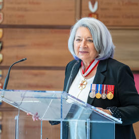 Governor General Mary May Simon stands at the podium addressing the audience.