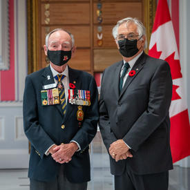 Mr. Whit Grant Fraser, who also took part in the ceremony, received a poppy from Mr. Larry Murray, Grand President of the Royal Canadian Legion.