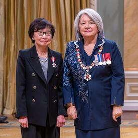 Janice Fukakusa est debout à côté de la gouverneure générale.