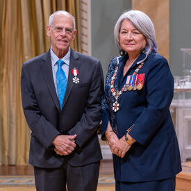 Peter Daniel Alexander Jacobs is standing next to the Governor General.