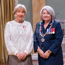 Judy Matthews is standing next to the Governor General.