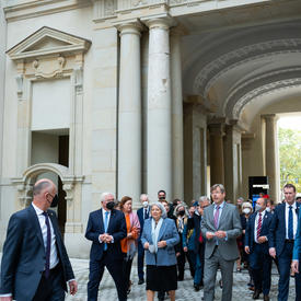 Son Excellence marche avec des membres du gouvernement allemand. La délégation canadienne suit derrière. Certaines personnes portent des masques.