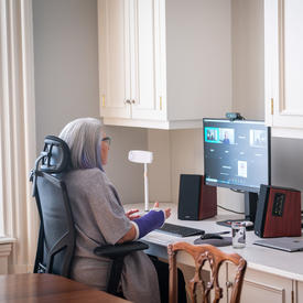 La gouverneure général est assise à un bureau. Elle participe à un chat vidéo sur son ordinateur. 