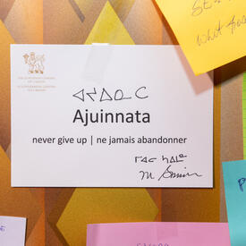Written on a white paper are the words ‘Ajuinnata. Never give up / ne jamais abandonner’. There is also the signature of Governor General Mary Simon as well as the Inuktitut translation. 