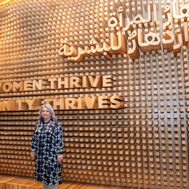 Governor General Mary Simon is standing in front of a wall with the words:  When women thrive humanity thrives.