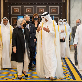 Their Excellencies are walking with a group of people. 