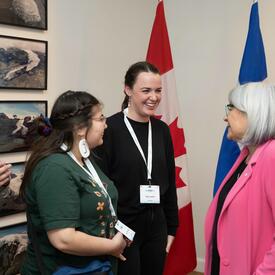 La gouverneure générale s'adresse à deux personnes dans une salle. Un drapeau du Canada et un drapeau de l'Islande sont en arrière-plan.