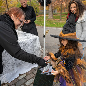 A girl receives candy dressed as a witch