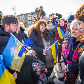 La gouverneure générale Mary Simon est debout au milieu d’un groupe de personnes. Plusieurs d’entre elles tiennent des drapeaux de l’Ukraine et de l’Union européenne.