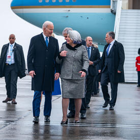 La gouverneure générale Simon marche à côté du président américain Joe Biden. Un groupe de personnes se trouve derrière eux.