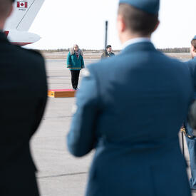 La gouverneure générale Mary Simon se tient debout à l'extérieur devant quelques personnes en uniforme.