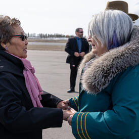 La gouverneure générale Simon serre la main de l’honorable Margaret Thom. Elles sourient.