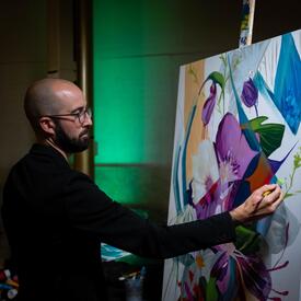 Un artiste peint une œuvre d'art lors d'un couronnement à Ottawa