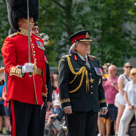La gouverneure générale Marie Simon marche avec le commandant de la Garde de cérémonie. Elle porte un uniforme de l'armée des Forces armées canadiennes.
