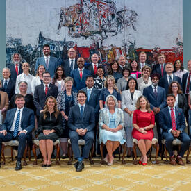 La gouverneure générale Marie Simon s'assoit avec le premier ministre Justin Trudeau et de nouveaux ministres pour une photo de groupe dans la salle de bal Rideau Hall