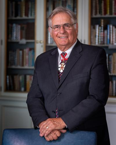 Photo officielle de Whit Grant Fraser. Des étagères de livres sont visibles à l'arrière-plan.