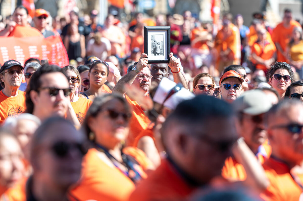un membre de la foule brandit une photo encadrée