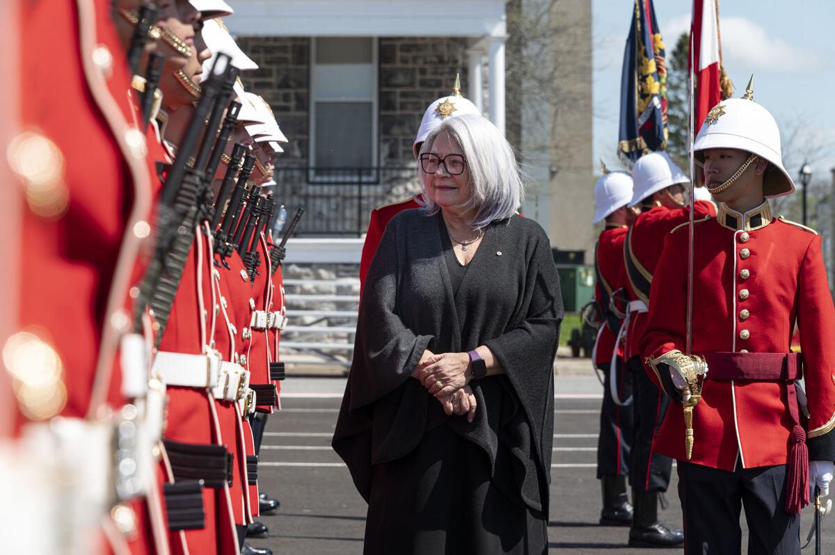 La gouverneure générale marchant le long d'une rangée d'élèves officiers et d'élèves officiers de marine.