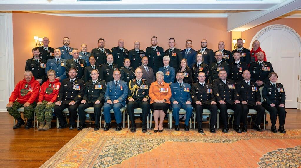 La gouverneure générale Simon et des membres des Forces armées canadiennes suivant une cérémonie de remise de l'Ordre du mérite militaire.