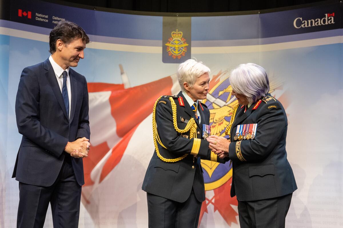 La gouverneure générale Mary Simon se tient à côté de la générale Jennie Carignan, nouvellement promue. Le premier ministre Justin Trudeau se tient à leur droite.