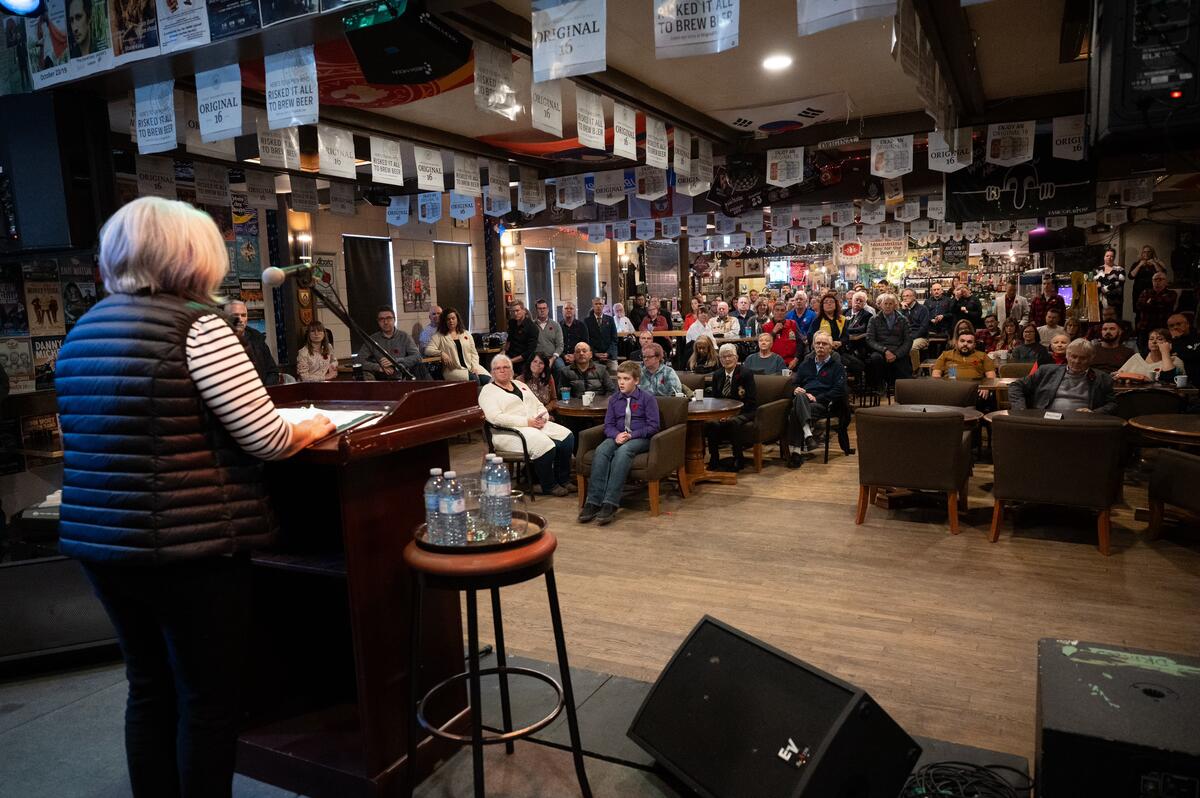 La gouverneure générale se tient sur une scène devant un groupe de personnes et livre un discours.