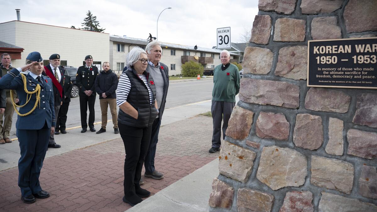 La gouverneure générale Mary Simon et Mr. Whit Fraser se tiennent devant un Monument commémoratif de guerre.