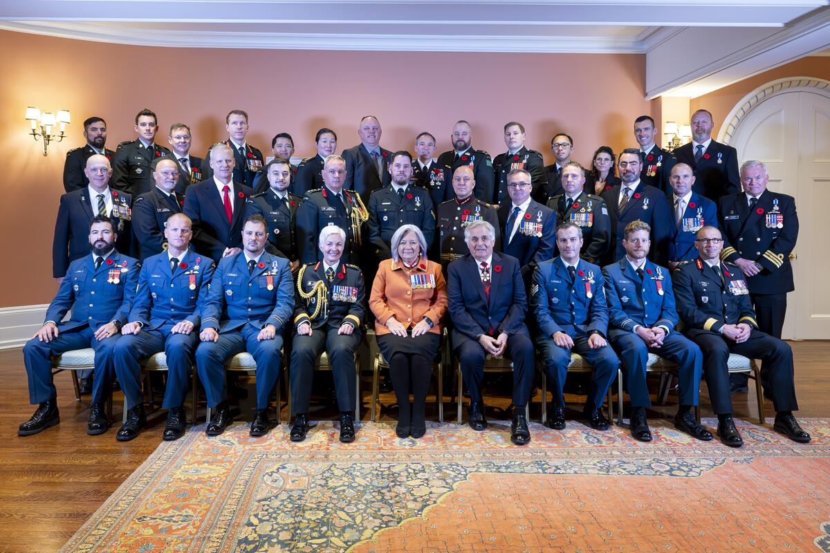 La gouverneure générale Simon et M. Fraser, assis au centre d'un grand groupe, posant pour une photo de groupe.